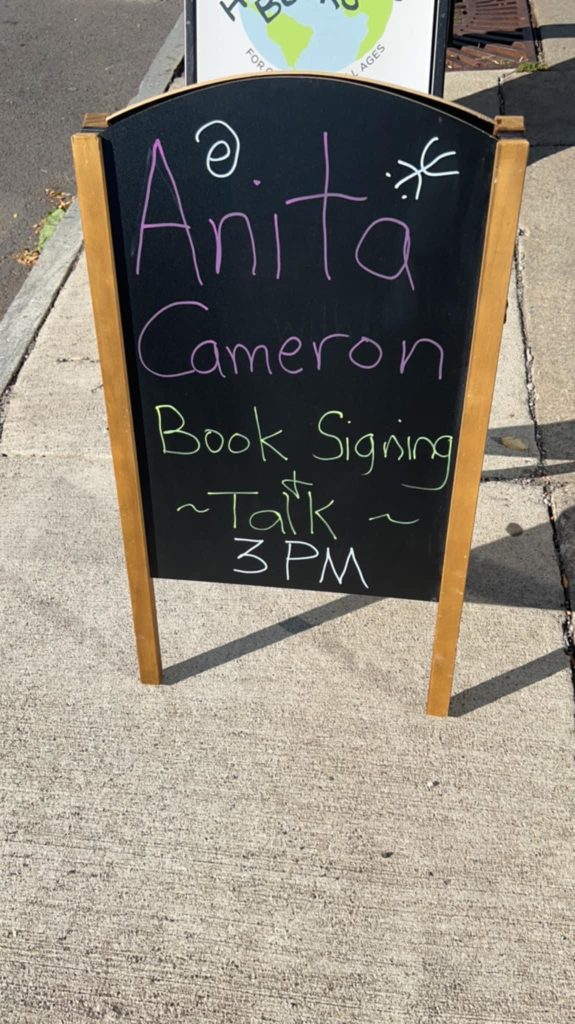 Hipocampo outdoor chalk sign that reads Anita Cameron Book Signing & Talk 3 PM.